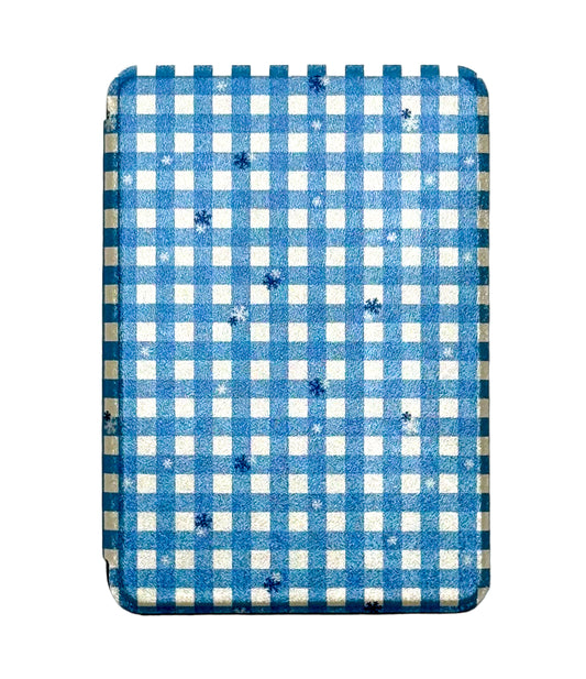 Blue and white checkered kindle case with scattered snowflakes on a white background